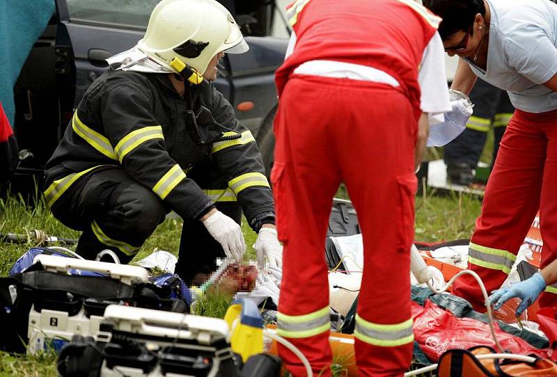 Záchranáři na místě resuscitují posádku osobního vozidla. Řidiči zaklíněnému v kabině už nebylo pomoci.