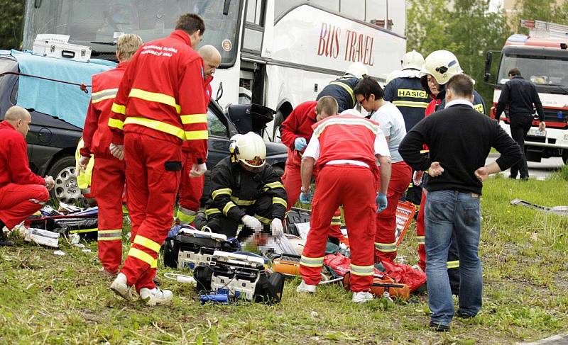 Záchranáři na místě resuscitují posádku osobního vozidla. Řidiči zaklíněnému v kabině už nebylo pomoci.