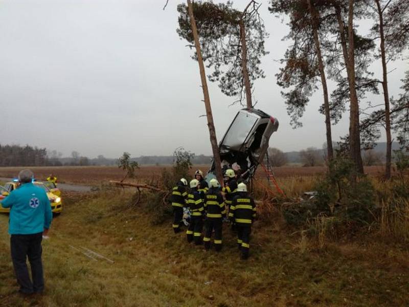 Vážná dopravní nehoda u Pohřebačky. Automobil skončil zaklíněný ve stromech u cesty.