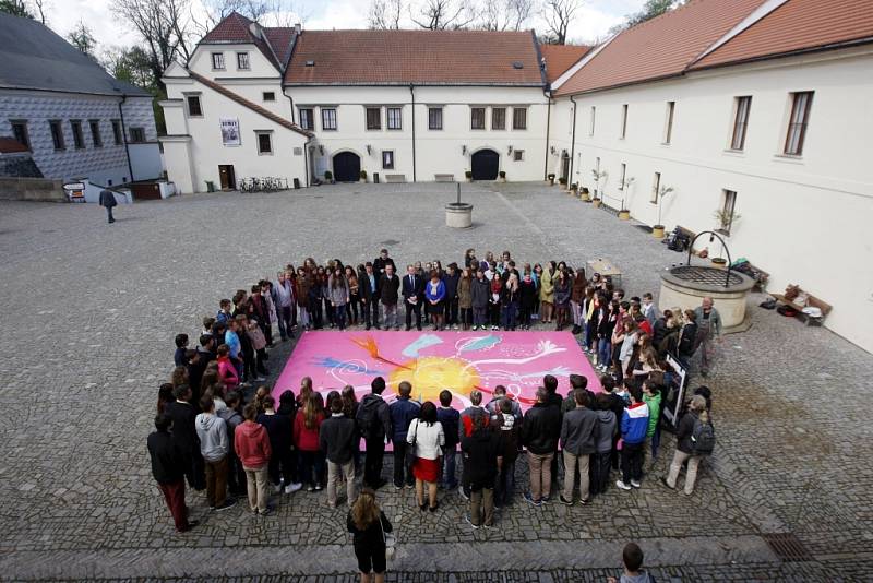 Studenti pardubického gymnázia Dašická spojili ruce nad zvětšeninou pastelu Ruce malíře Karla Malicha.