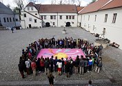 Studenti pardubického gymnázia Dašická spojili ruce nad zvětšeninou pastelu Ruce malíře Karla Malicha.