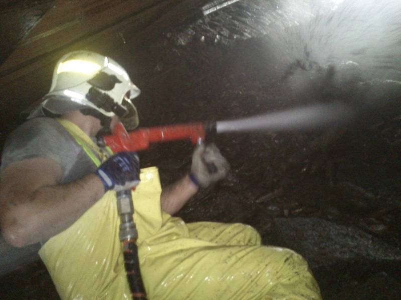Dobrovolní hasiči z Lázní Bohdaneč pomáhají s vyklízením ucpaného tunelu.