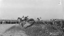 Velká pardubická steeplechase, skok jezdců přes překážku, zřejmě před rokem 1914.