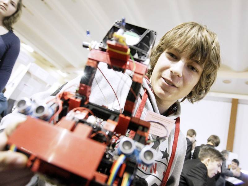 Kamil Mudruňka s robotem schopným automaticky zhášet hořící svíčky.