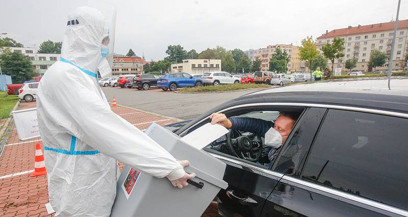 V krajských volbách odvoleno. Lidé v karanténě hodili svůj hlas do urny skrz okénko v autě na parkovišti za pardubickou enteria arenou.