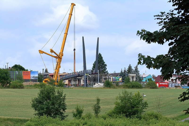 Ocelovou lávku pro pěší instalují technici přes čtyřproudovou ulici U Seřadiště. Ta zároveň překlene i modernizovanou železniční trať a nahradí tak stávající čtyřkolejný přechod do ulice Na Lipce.