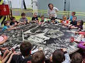 Dobrodruzi je název aktuální interaktivní výstavy o cestě emigrantů ze Stoda na Nový Zéland, která inspirovala také nadcházející příměstské tábory v DEPO2015. Snímek je ze závěru výstavy, kde děti posedí nad fotografiemi vesnice Puhoi. 