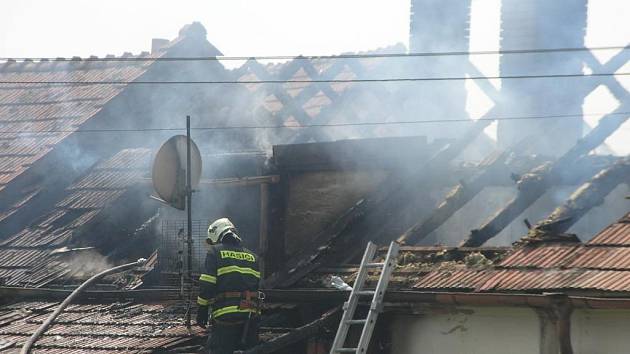 Hasiči rozebírají střechu a hasí zbytky požáru