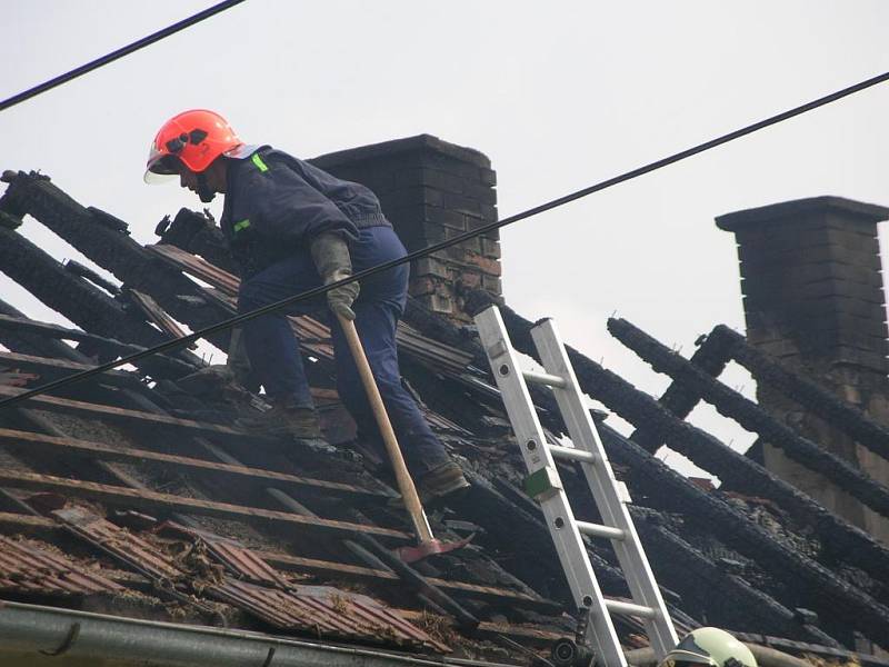 Hasiči rozebírají střechu a hasí zbytky požáru