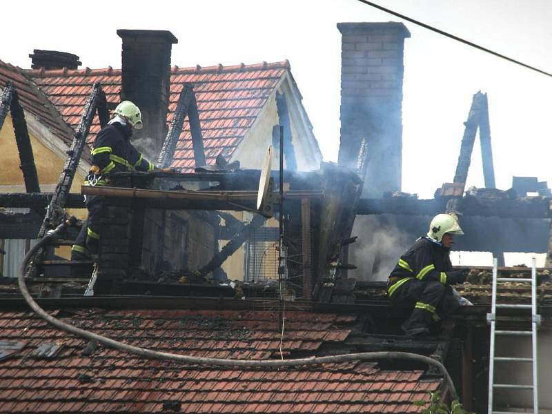 Hasiči rozebírají střechu a hasí zbytky požáru