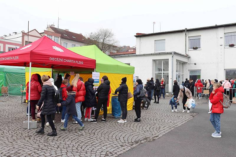 Uprchlíci stojí před plzeňským skladem v Cukrovarské ulici ve frontách, snímek je ze čtvrtečního rána.