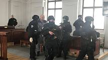Josef Kott s eskortou u soudu 29. března 2022. Za mřížemi je doživotně odsouzený vrah už 31 let.