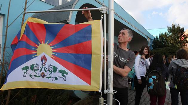 Vlajka pro Tibet. Student Křižíkova gymnázia Jan Anderle před buduvou školy vyvěšuje tibetskou vlajku.  Škola se tak připojuje ke světové kampani na podporu Tibetu