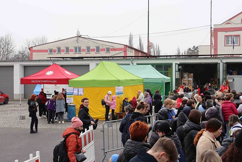 Uprchlíci stojí před plzeňským skladem v Cukrovarské ulici ve frontách, snímek je ze čtvrtečního rána.