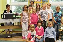 Malí zpěváci z dětského souboru Lukaváček nacvičují písně za doprovodu vedoucí Nadi Květoňové (úplně vlevo)
