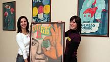 Pracovnice Espritu Václava Sporková (vlevo) a Tereza Štichová ukazují plakát k filmu Piti piti pa, který je společně s dalšími díly Karla Vaci vystaven v Besedě