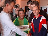 Fotbalový trenér  Stanislav Purkart předává knihu Vzestupy a pády Viktorie Plzeň  uživatelům služeb Domova pro osoby se zdravotním postižením ve Stodě