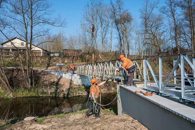 Jeřáb ve středu usadil novou lávku přes Radbuzu v Ohučově. Aby se nepřetočila, dělníci ji pomocí lan jistili. Do týdne bude hotová i cyklostezka z obce do Dolní Kamenice.