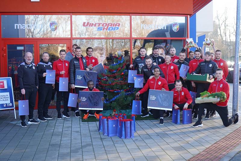 JAN KOPIC s kufrem auta plným vánočních dárků, které přinesli lidé pod stromeček u klubového fanshopu. Před odjezdem do Karviné tam zašli i jeho spoluhráči.