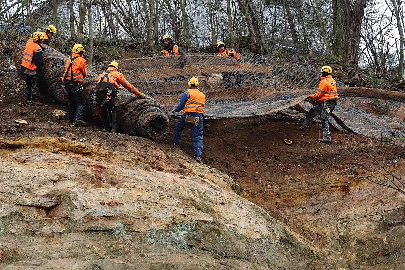 Práce na pískovcové skále v Lobezském parku v Plzni – Doubravce. Specializovaná firma provádí v těchto dnech očištění stěny, odstranění nestabilních částí a instalaci ochranné sítě s vegetačními pásy, které zabrání prorůstání kořenů vegetace do skály.