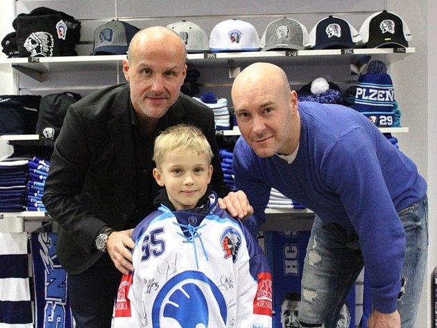 Martin Straka (vlevo) spolu se sportovním manažerem Tomášem Vlasákem pózuje v klubovém fanshopu s malým fanouškem.