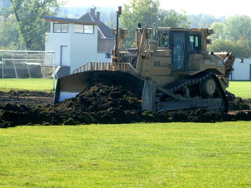 Buldozer právě odstraňuje přírodní trávnatý povrch  na tréninkovém hřišti v areálu doubraveckého Senka