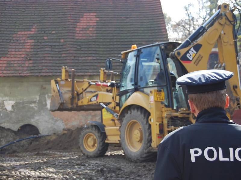 Ve čtvrtek se v Chotěšově opět pracovalo. Bagr zahrnoval příkop za dohledu policie