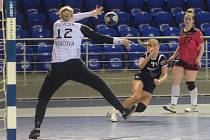 Brankářka DHC Plzeň Karin Řezáčová čleí střele házenkářky Iuventy Michalovce. Akci přihlíží Dominika Galušková.