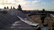 Silným větrem utržená část střechy na tělocvičně dobříšské základní školy.
