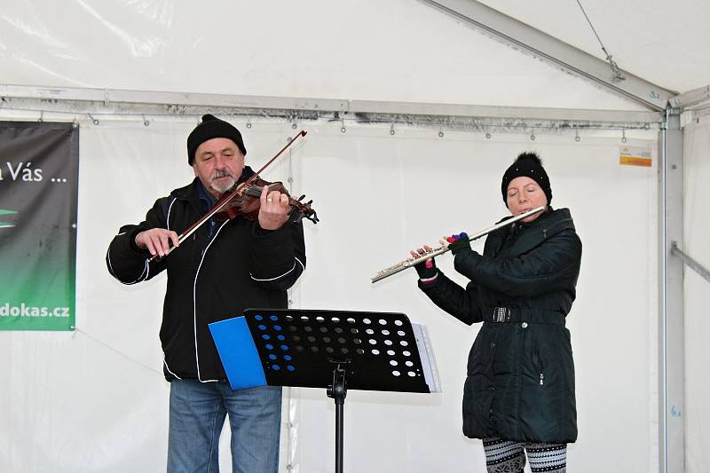 K nákupům zeleniny, ovoce, medu, adventní výzdoby a horkých nápojů návštěvníkům zahrál koledy Pokleslý orchestr lidových umění Dobříš.