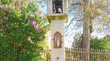 Z kamene tesaná zvonička z roku 1905 ve Veletíně, v jejíž přední části je zašpičatělý výklenek se soškou.
