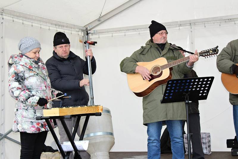 K nákupům zeleniny, ovoce, medu, adventní výzdoby a horkých nápojů návštěvníkům zahrál koledy Pokleslý orchestr lidových umění Dobříš.