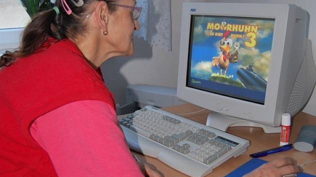 Senioři se učí pracovat na počítači. 