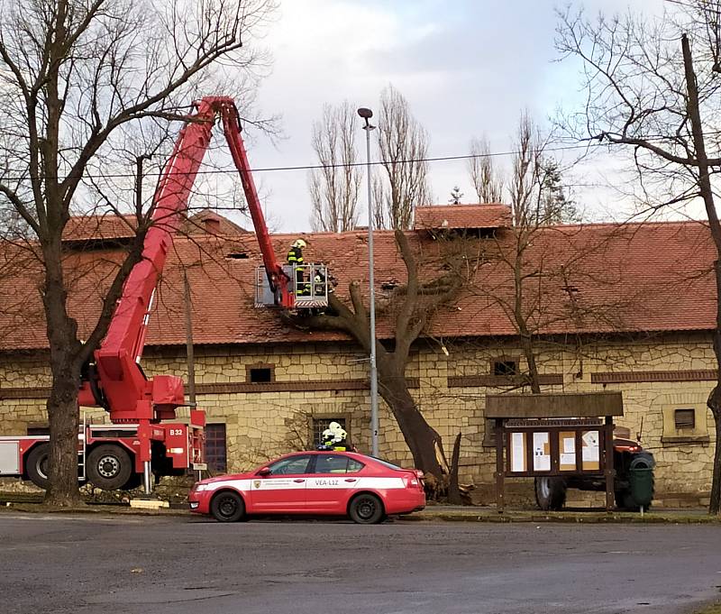 V Olešné spadl kvůli silné vichřici strom na jednu z hospodářských budov zámku. Hasiči ho museli odstranit pomocí vysokozdvižné plošiny.