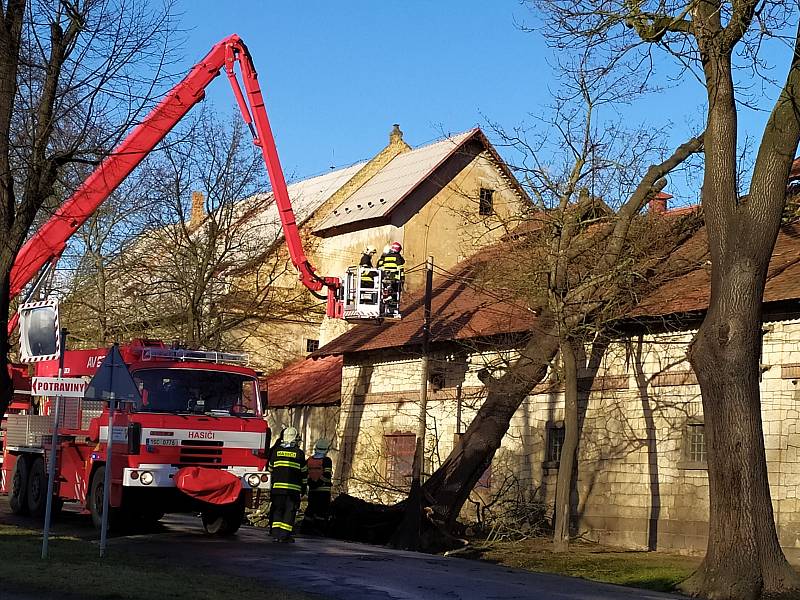 V Olešné spadl kvůli silné vichřici strom na jednu z hospodářských budov zámku. Hasiči ho museli odstranit pomocí vysokozdvižné plošiny.