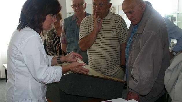 Renata Mayerová ředitelka rakovnického archivu ukazuje archiválie návštěvníkům