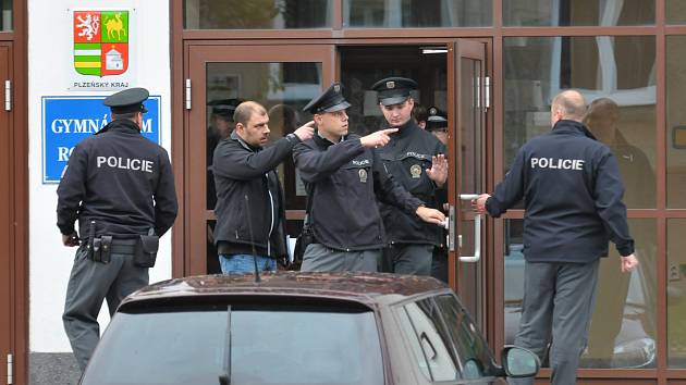 Policie opouští prohledanou budovu Gymnázia Rokycany a míří ke střední škole, která stojí jen pár desítek metrů vedle.