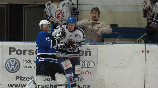 Hokejisté SKP remizovali s vedoucím mužstvem krajského přeboru 4:4. Souboj rokycanského Václava Kočího (v bílém) a plzeňského hokejisty. Jak je ze snímku vidno, i trenér může snadno přijít k úhoně.  