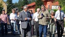 Starosta František Končel (v popředí) po úterním otevření nových asfaltových komunikací v Kařízku čelí tlaku spoluobčanů, kteří požadují opravu cest u jejich domů.