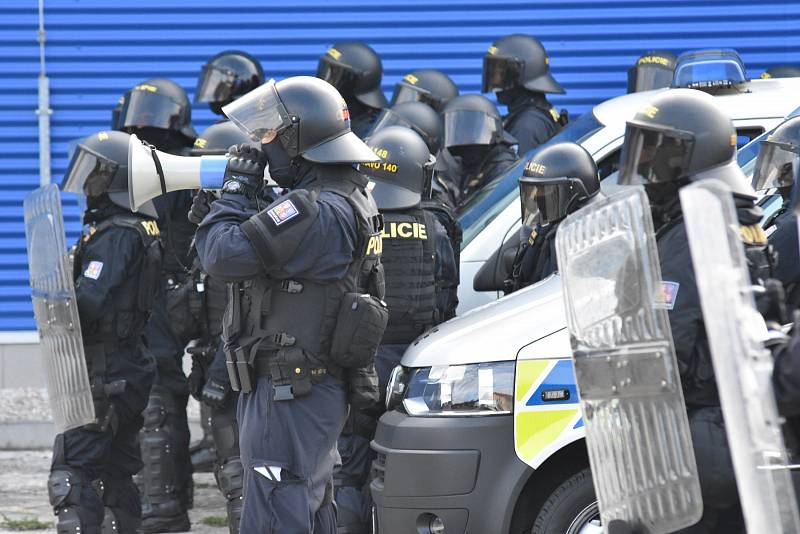 Policejní kordon pochoduje proti demonstrantům.