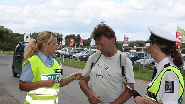 DOPRAVNĚ BEZPEČNOSTNÍ AKCE BYLA v minulém týdnu zaměřená na cyklisty a motoristy. Na snímku mluvčí PČR Hana Kroftová (vlevo) předává cyklistovi reflexní pásku. 