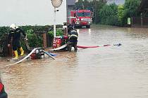 Dobrovolní hasiči v Mirošově likvidují následky vydatných dešťů.