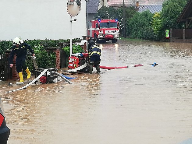 Dobrovolní hasiči v Mirošově likvidují následky vydatných dešťů.