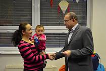 Vedoucí oddělení komunikace Charity Česká republika František Coufal předává poukazy „dm pomáhá dětem“ rodině z Českých Budějovic.