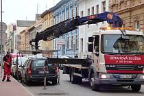 Odtahová služba nakládá osobní automobil v Kostelní ulici. Podle nového opatření totiž parkovalo na místě vyhrazeném pro zastavení autobusů.