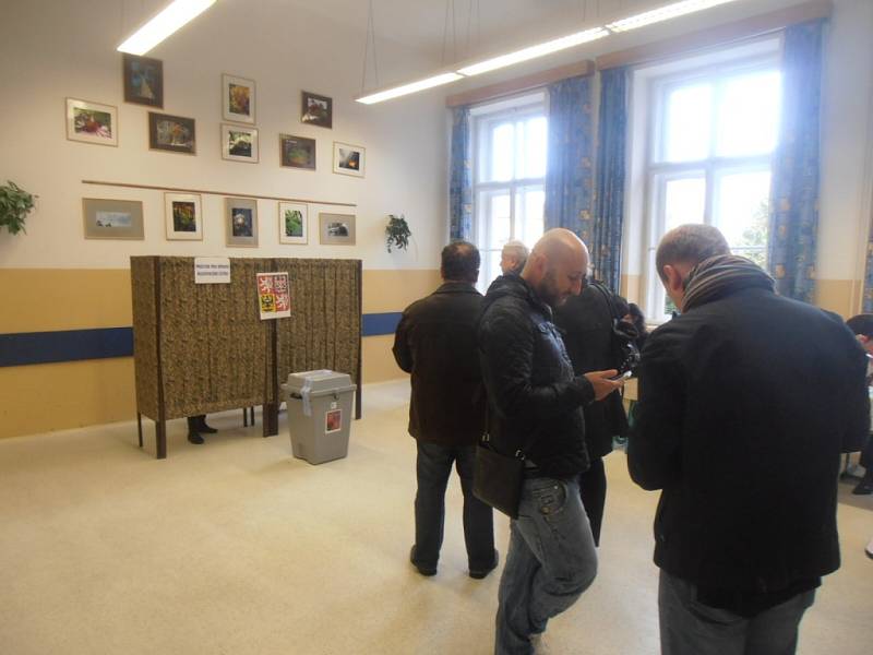 V budově gymnázia v českobudějovické České ulici se voliči míjejí s účastníky páteční oslavy 110. výročí otevření budovy gymnázia. 