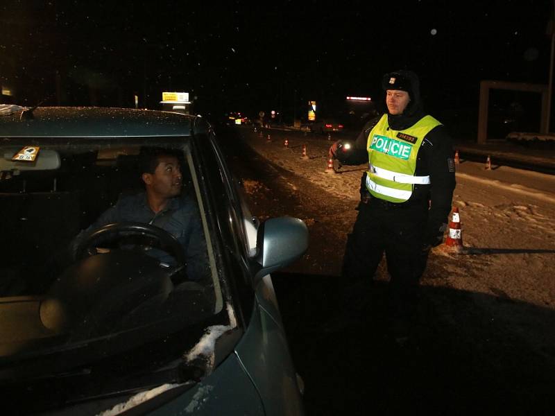 Policisté, kteří kontrolují auta na hraničním přechodu Dolní Dvořiště, zažívají nyní mrazivé noci, kdy teplota padá k minus deseti a ještě níž. Nejhorší pro ně je ledový vítr. Na snímku z neděle 17. ledna Miroslav Rojdl.
