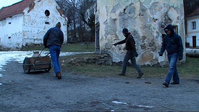 Klienti ve filmu navážejí v konvi vodu. Vlevo řídí kárku herec Jaromír Dulava (Ruda).