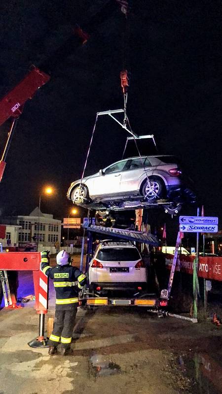 Tahač převážející osobní auta měl poškozený nosník. Hasiči v Českých Budějovicích ve středu v časných ranních hodinách museli náklad zajistit a nebezpečně nakloněné auto sundat.