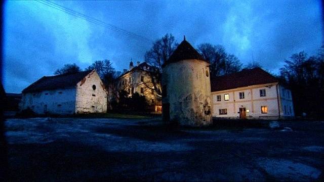 Noční záběr na němčický zámek s budovami, vpravo sídlo komunity, vepředu stojí rotundovitá šatlava.